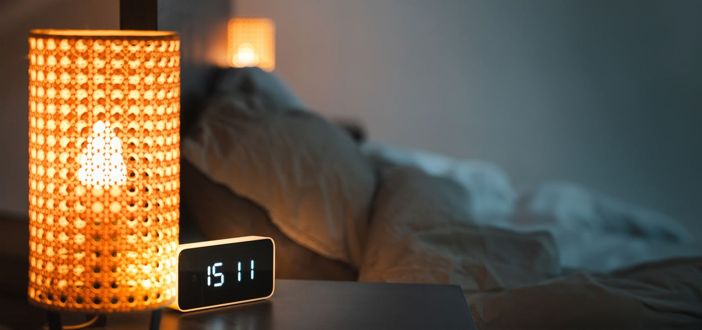 Despertador y luz de mesilla para una guía sobre despertarse a las 3 de la mañana