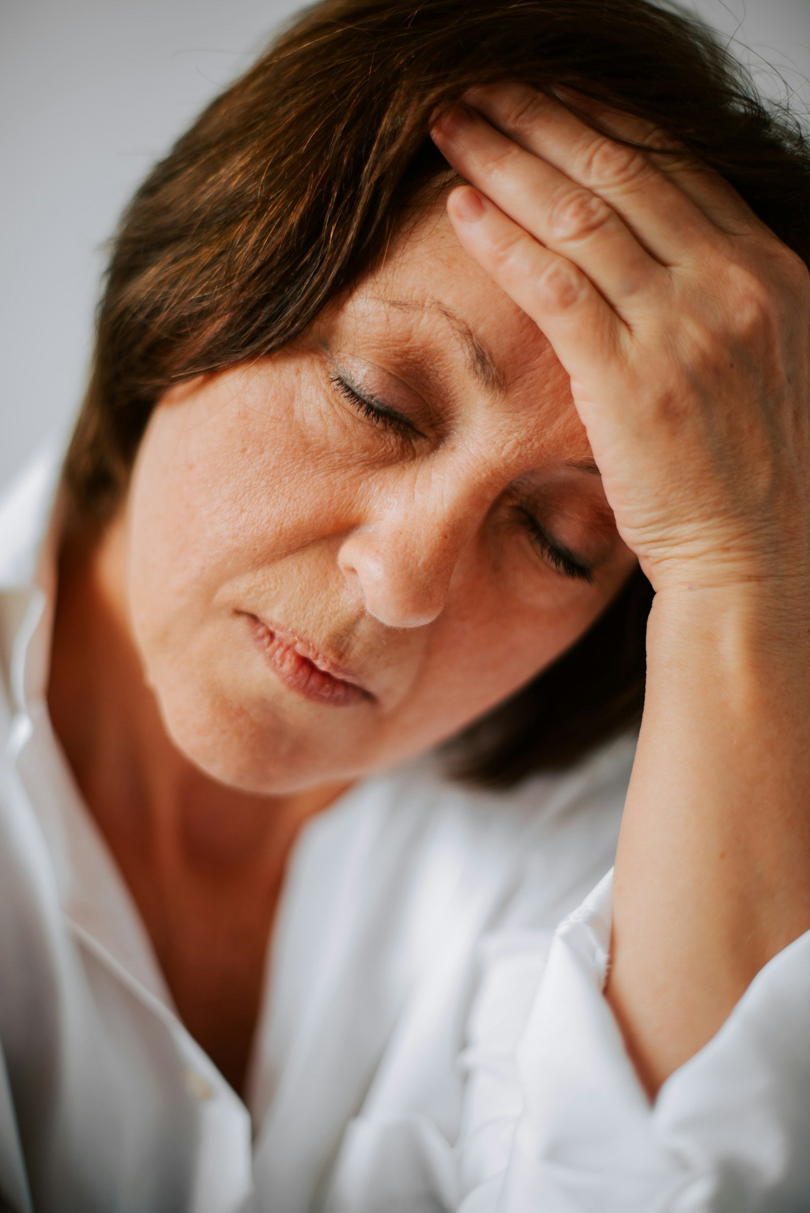 Mujer en casa con luz natural leyendo sobre síntomas de la menopausia
